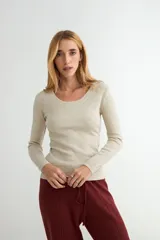 Sweater de punto fino en color beige, con escote redondo y mangas largas, de corte ajustado al cuerpo.