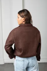 Campera corta de gamuza color chocolate, con cierre frontal, cuello camisero, bolsillos frontales con solapa y puños con botones.