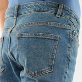 Pantalón de jean azul con corte recto y cintura elástica diseñada para el embarazo.