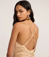 Vestido midi ajustado de satén color beige, con breteles finos regulables, escote en V, recorte con aro en el busto y cierre con cremallera en la espalda.