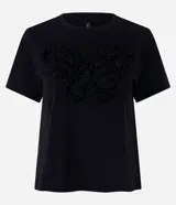Remera negra de algodón con cuello redondo, manga corta y bordado frontal en relieve con forma de mariposa.