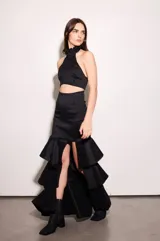 Top de tafeta color negro con escote halter y volados en el cuello, ajuste al cuerpo, espalda baja y cierre con botones.