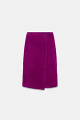 Falda midi de tiro medio tipo pareo confeccionada en piel. Presenta un diseño cruzado con cierre frontal y bajo asimétrico.
