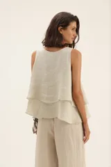 Musculosa de lino en color beige, con diseño de capas superpuestas que crean un efecto de volados en el frente.