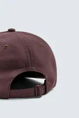Gorra de seis paneles color marrón oscuro con visera plana. Presenta bordado frontal en color rosado claro con el texto "new jersey" y el número "75".
