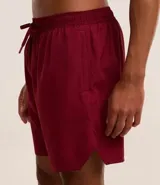 Bermuda deportiva masculina de color gris azulado, confeccionada en tejido técnico con textura perforada. Presenta cintura elástica con cordón de ajuste y diseño funcional para entrenamiento.