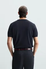 Camiseta negra de punto con cuello redondo, manga corta y corte regular. Tejido de viscosa con acabado en rib.