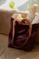 Bolso tipo tote de cuero con pelo color marrón y blanco, con manijas de cuero crudo.