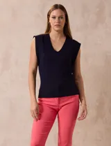 Buzo tejido en hilado fino color beige, con escote en V y sin mangas.