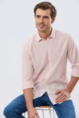 Camisa de lino rosada con rayas sutiles, de manga larga y cierre frontal con botones.