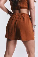 Short color marrón con cintura elástica y bolsillos laterales.
