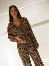 Conjunto de pijama con estampado animal print, compuesto por camisa de manga larga con botones y pantalón largo.