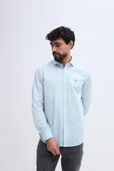 Camisa de manga larga fit semi slim color celeste, con cierre frontal de botones y cuello camisero clásico.