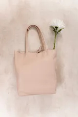 Bolso tote grande de cuero negro con doble asa larga y cierre superior con tira de cuero. Diseño minimalista y atemporal.