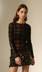 Top de manga larga confeccionado en tejido transparente con diseño de cuadros negros. Presenta un corte al cuerpo y cuello a la base.