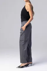 Pantalón babucha gris de cuero sintético con cintura elastizada y bolsillos laterales con solapa.