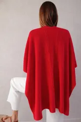 Ruana tejida en baby alpaca de color rojo tomate, con textura liviana y corte recto de caída fluida.