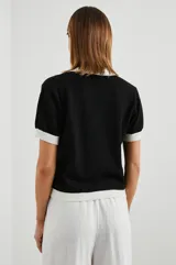 Remera negra de punto con cuello polo y ribetes blancos en cuello y mangas.