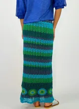 Pollera larga tejida a crochet con diseño de rayas horizontales en tonos naranja, fucsia y morado.