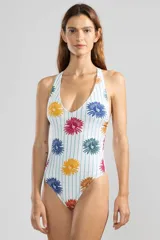 Malla enteriza blanca con estampado de flores de colores y rayas verticales celestes.