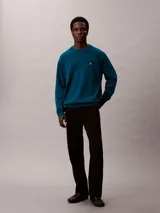 Sweater Calvin Klein de corte relajado, color azul oscuro, con cuello redondo y el logotipo CK bordado en contraste en el pecho. Presenta puños, cuello y dobladillo acanalados.