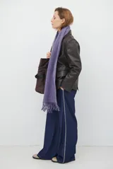 Blazer de cuero color marrón, con corte entallado, cuello con solapas, cierre frontal con botones y bolsillos laterales con solapa.