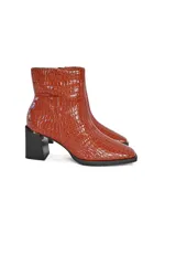Botines de cuero vacuno con acabado efecto croco brillante en color caramelo. Presentan un diseño de caña media con puntera cuadrada, cierre lateral discreto y un tacón bloque robusto en color negro.