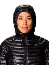 Campera puffer ultraligera con capucha, confeccionada en tejido ripstop reciclado con acabado brillante. Cuenta con cierre frontal, bolsillos laterales con cremallera y puños elásticos. Relleno de plumón de alta capacidad térmica.