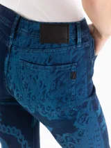 Jeans oxford de tiro medio-bajo, confeccionados en mezcla de algodón y elastano. Presentan un diseño ajustado hasta la rodilla y terminación acampanada, con un patrón gráfico de grabado láser cyanotype en tonos azules sobre base oscura.