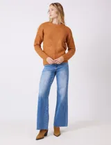 Buzo de lana melange color tostado, con cuello redondo y mangas largas.