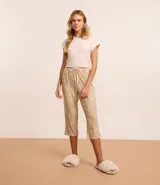 Conjunto de pijama de dos piezas, compuesto por una remera de mangas cortas color rosa claro con detalles de satén y un pantalón capri con estampado floral y lazo en la cintura.