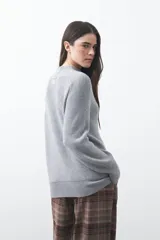 Polera de tejido de punto en color marrón oscuro, con cuello alto y diseño de silueta relajada.