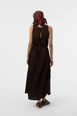 Vestido midi sin mangas de color marrón, confeccionado con textura arrugada, escote redondo, silueta relajada y caída liviana, con un lazo fino ajustable en la cintura.