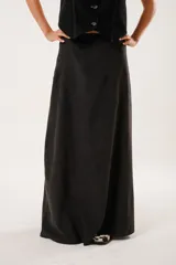 Falda larga negra confeccionada en tela suave con acabado tipo piel de durazno y cierre invisible lateral.