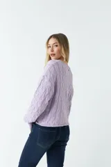 Sweater tejido con trama de ochos color lila, de calce relajado y cuello redondo.