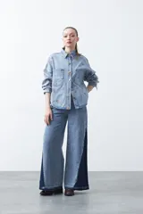 Sobrecamisa de denim color negro con bordado floral en tonos tierra, bolsillos frontales y botones metálicos.