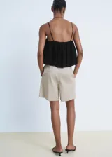 Top negro de viscosa con tirantes finos ajustables, escote recto y diseño crop estilo globo, con forro interior de poliéster.