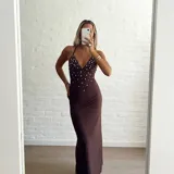 Vestido largo marrón con escote halter y espalda descubierta, con apliques de strass plateados en el corpiño.