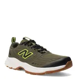 Championes de trail running New Balance modelo 410, color verde militar con detalles en negro y amarillo flúor, entresuela blanca y suela de goma marrón. Confeccionados con malla y refuerzos sintéticos, cuentan con cordones negros y tirador trasero.