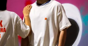 Remerón unisex de algodón color crudo con cuello redondo y estampado en la espalda con la inscripción "DELK BRISHA CLUB" en color naranja.