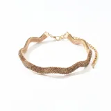 Gargantilla dorada con tejido de malla brillante y cadena de extensión.