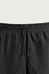 Short de baño largo en color beige, confeccionado en tejido técnico con tacto aterciopelado. Cuenta con cintura elástica ajustable con cordón, bolsillos laterales y detalle de bolsillo trasero, además de forro interior.