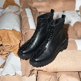 Bota corta de cuero vacuno color negro, con diseño de punta cuadrada y detalle de textura tipo cocodrilo en la parte central. Cuenta con suela de goma tipo track y cierre lateral interno.