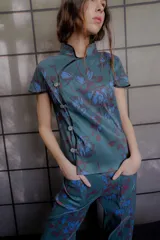 Top de tafeta elastizada con estampado floral, cuello mao, mangas cortas y cierre frontal asimétrico con botones.