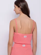 Top sin mangas de tela texturada color verde lima, con tirantes finos y escote cuadrado con detalle de terminación festoneada.