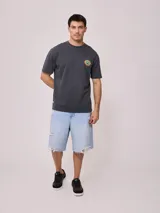 Remera color crema de corte holgado con estampado circular en el pecho.