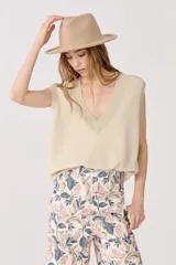 Chaleco tejido color dorado con lurex, escote en V y terminaciones de rib.