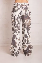 Pantalón wide leg blanco con estampado de vaca, con cierre y botón en la cintura.
