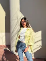 Camisa oversize a rayas de manga larga, con cuello camisero y cierre frontal de botones.