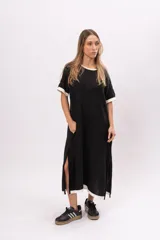 Vestido remerón largo de manga corta color negro, con cuello y puños blancos, y aberturas laterales.